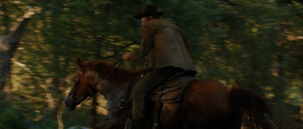 Texas Legacy in Lights — a rider on horseback gallops through the woods at dusk